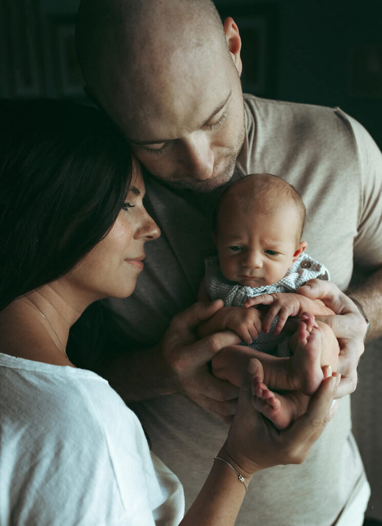 Family is holding their newborn baby boy in their Livingston NJ home