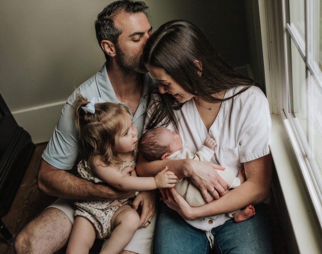 Family of mom, dad and a toddler holding a newborn baby in their Long Valley,NJ home